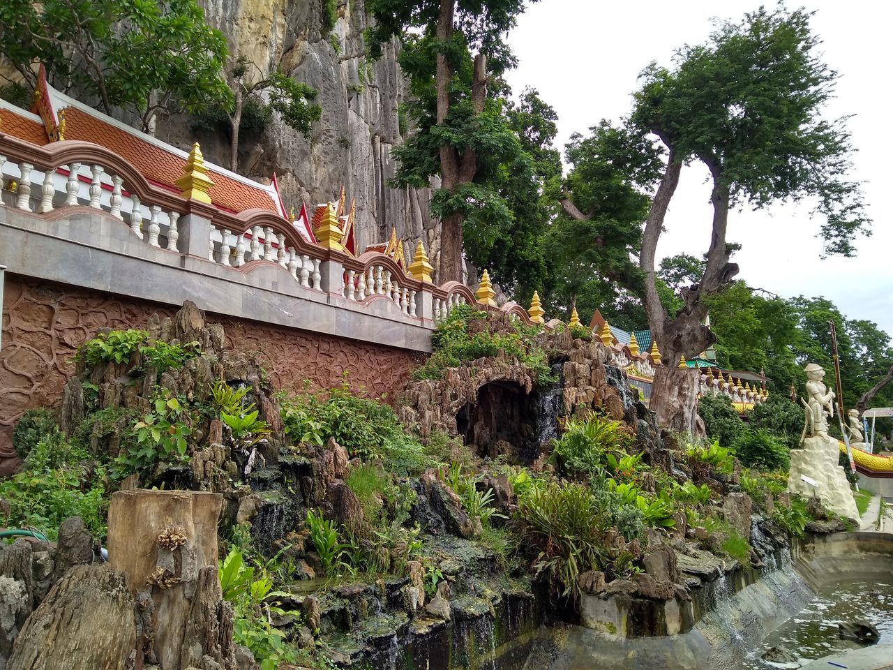 BRIDGE OVER RIVER AMIDST TREES AND BUILDINGS