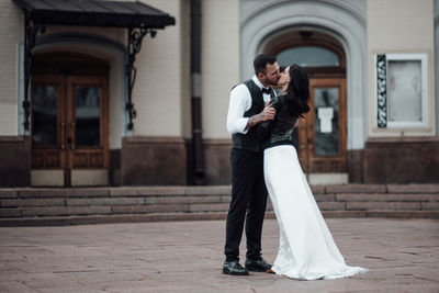 Full length of couple standing in front of building