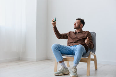 Young man sitting on sofa at home