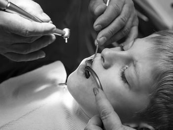 Close-up of dentist examining teeth of boy at clinic