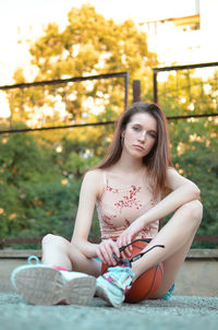 Portrait of young woman sitting on bench