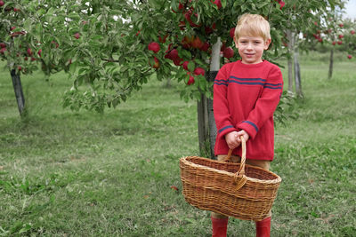 Portrait of smiling young woman holding wicker basket