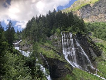 Scenic view of waterfall against sky