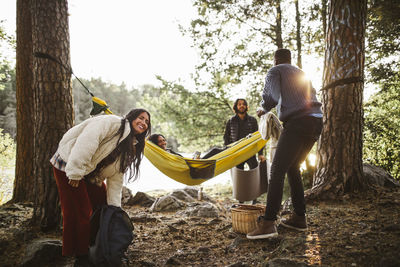 Male and female friends enjoying in forest during vacation