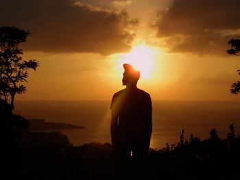 Silhouette of people on beach at sunset