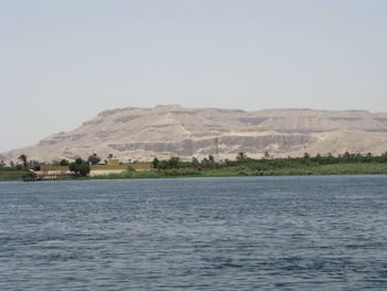 Scenic view of sea and mountains against clear sky