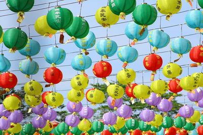 Low angle view of multi colored balloons hanging on wall