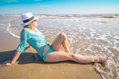 Woman sitting on shore at beach