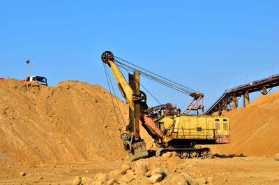 Cranes at construction site against clear sky