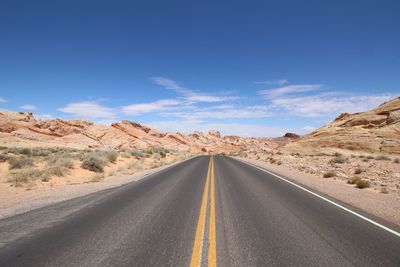 Road amidst desert against sky