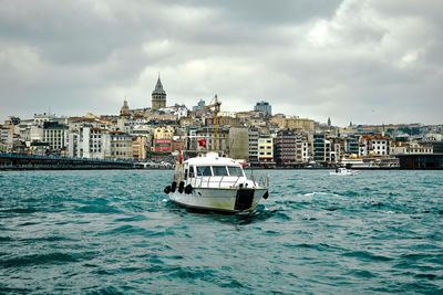 Boat in sea against buildings in city