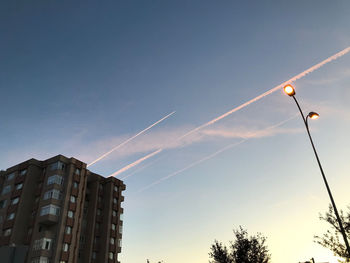 Low angle view of street light and building against sky