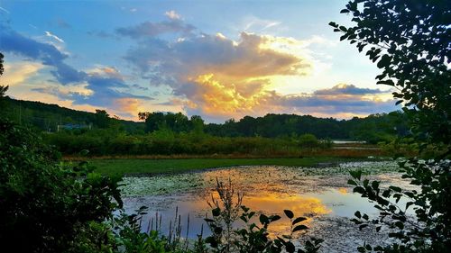 Scenic view of farm against sky during sunset