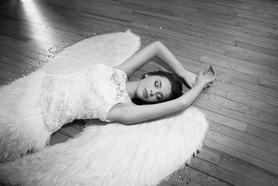 Young woman in dress sleeping on hardwood floor