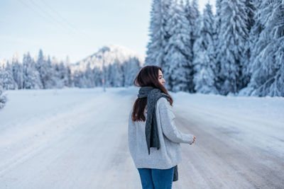 Rear view of woman standing on snow