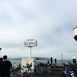 Road sign against cloudy sky