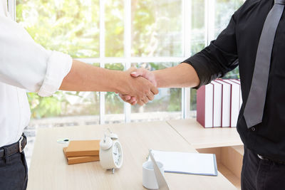 Midsection of businessmen shaking hands