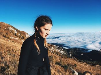 Young woman standing by sea against clear sky