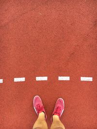 Low section of man standing on running track