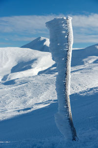 Snow covered mountain against blue sky