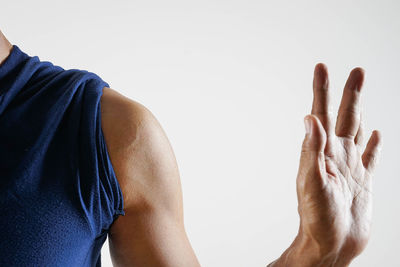 Midsection of man wearing hat against white background