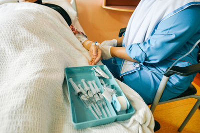 Midsection of nurse holding iv drip of patient