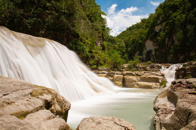 Scenic view of waterfall against rocks
