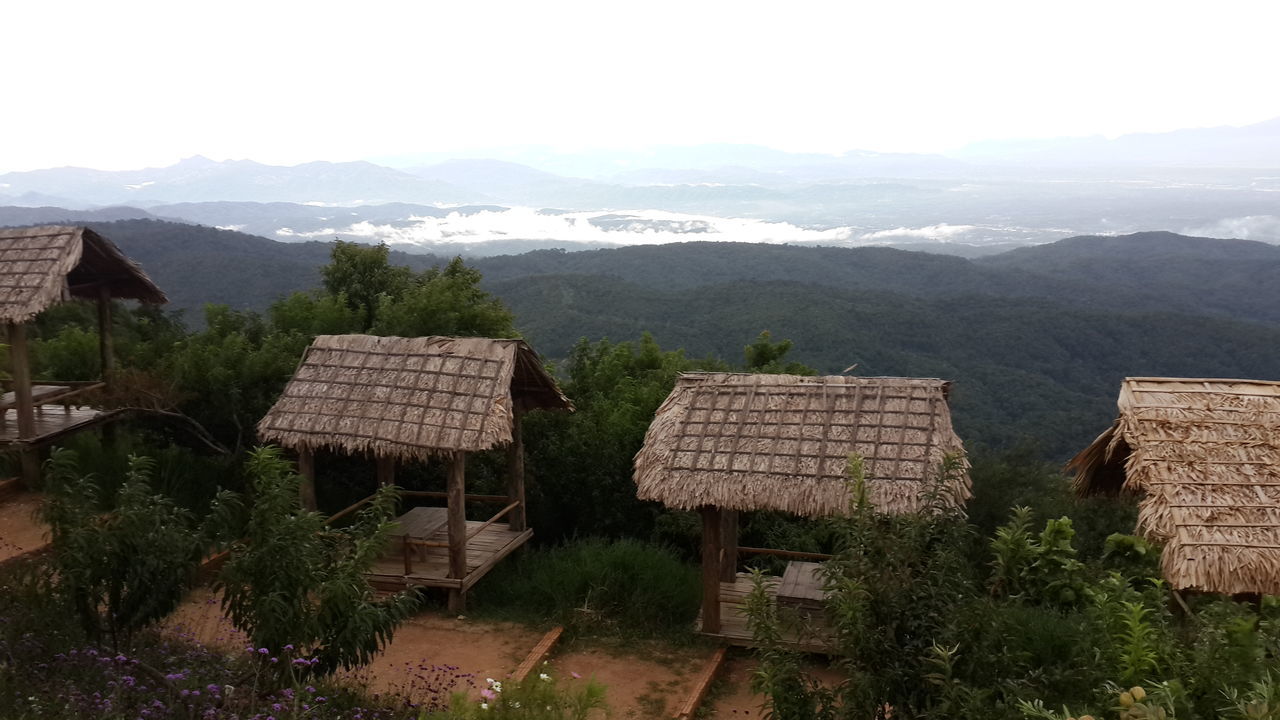 mountain, built structure, house, building exterior, mountain range, architecture, landscape, tranquility, tranquil scene, scenics, nature, sky, roof, high angle view, tree, clear sky, village, beauty in nature, residential structure, day