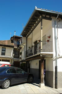 View of street and buildings against blue sky