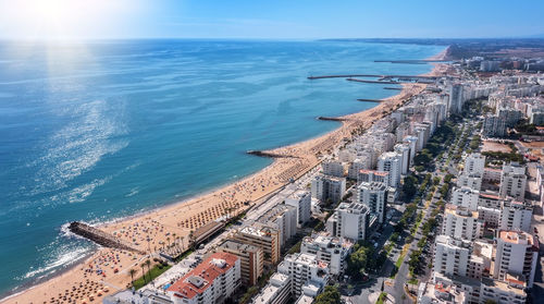 High angle view of buildings by sea against sky