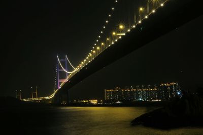 Low angle view of illuminated bridge against sky at night