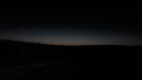 Silhouette landscape against clear sky at night