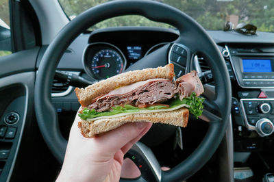 Cropped hand of person holding steering wheel