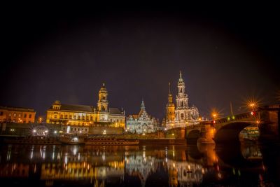 Illuminated bridge over river at night