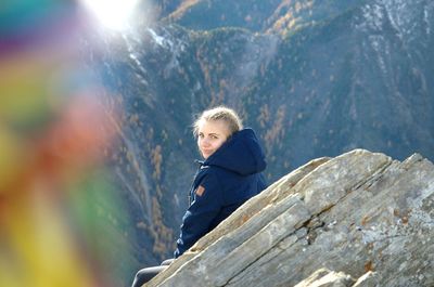 Portrait of smiling woman sitting on rock