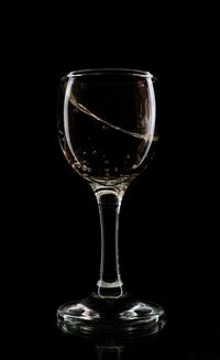 Close-up of wineglass against black background