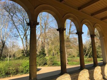 Trees and building seen through colonnade