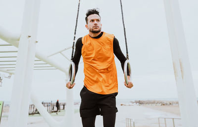 Man exercising on beach against sky