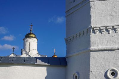 Low angle view of lighthouse by building against sky