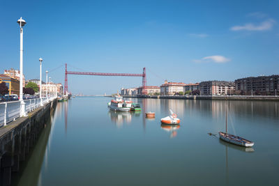 Bridge over river in city against sky