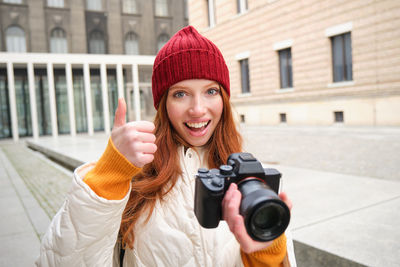 Young woman holding camera