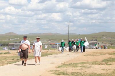 Rear view of people walking on beach