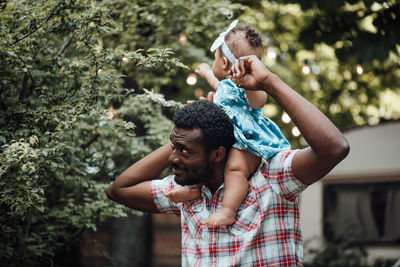 Full length of father and daughter against trees