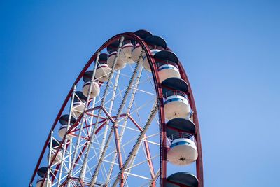 Low angle view of ferris wheel against blue sky