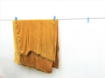 Textile drying on clothesline against wall