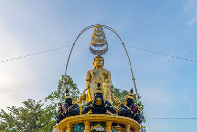 Low angle view of statues against sky