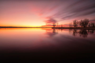 Scenic view of lake against romantic sky at sunset