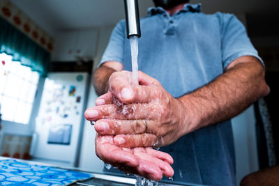 Midsection of man working in kitchen