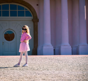 Full length rear view of woman standing against wall