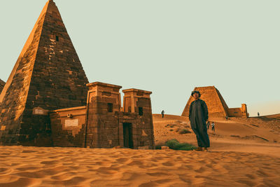 Man standing by old ruins of temple